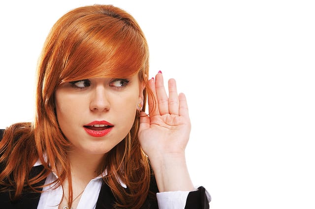 State College - Business woman with hand to ear listening isolated