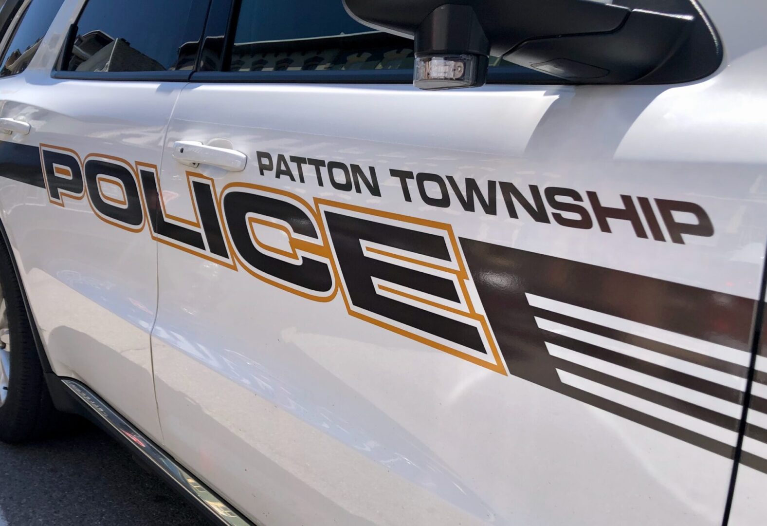 A police cruiser with "PATTON TOWNSHIP POLICE" in black and yellow letters on the door.