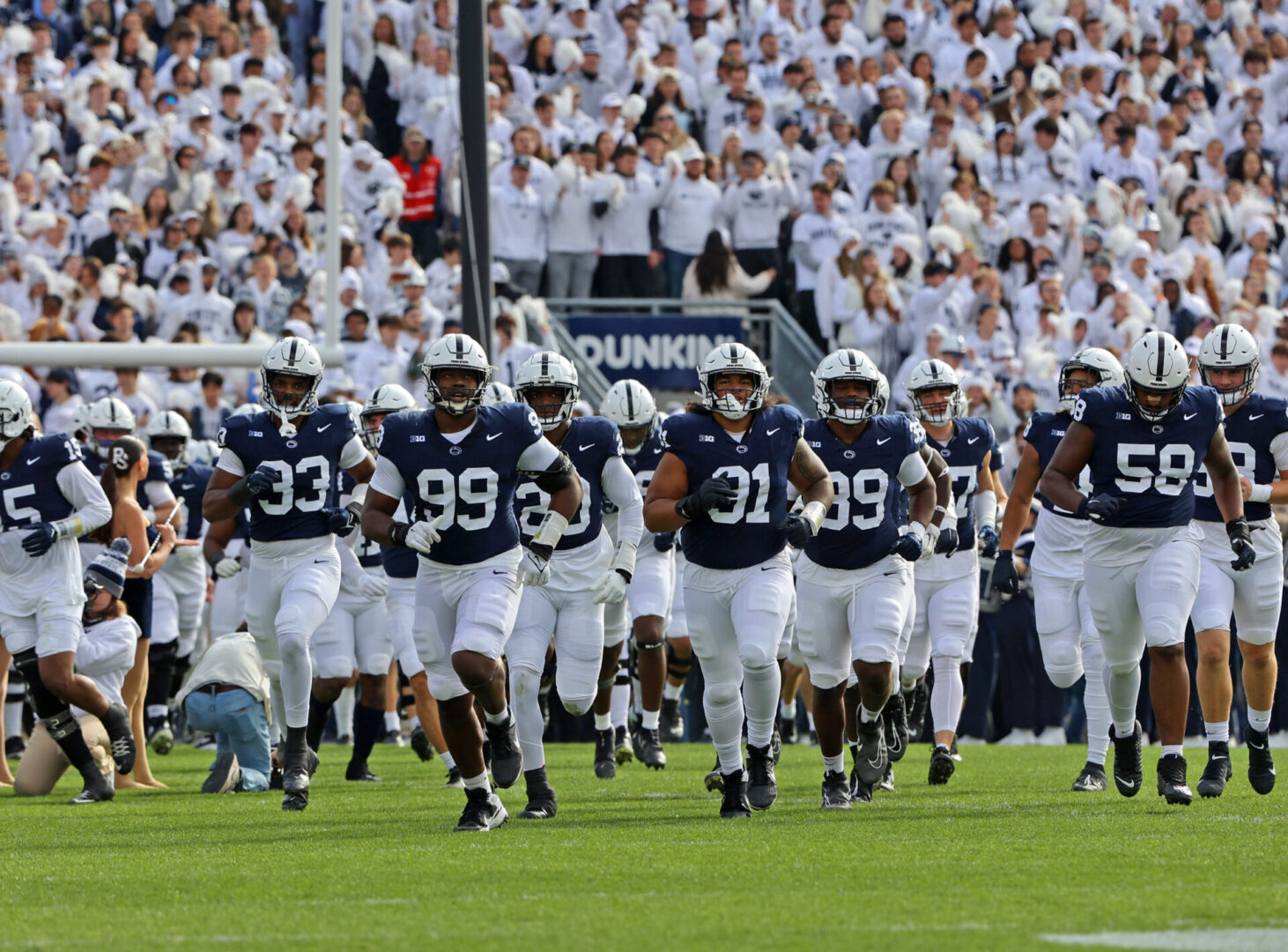 State College - football running on field michigan 2023