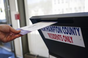 A voter puts a ballot into a drop box on primary Election Day 2024 at Bethlehem City Hall in Northampton County, Pennsylvania.