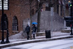 Two people walk in the snow on South Fraser Street in State College on December 15, 2924