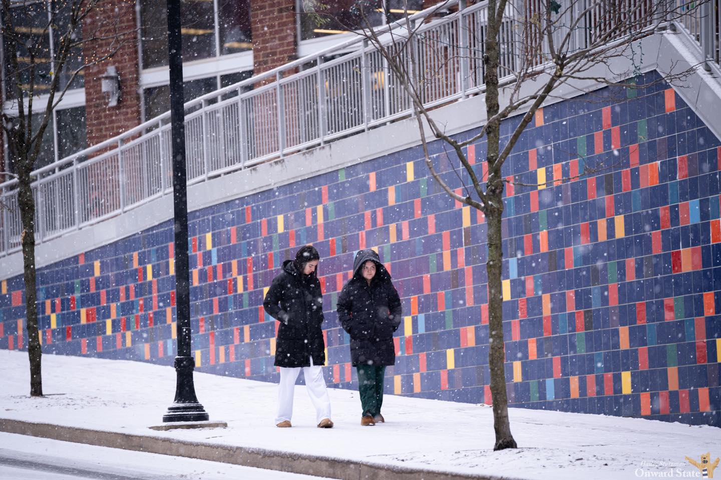 Two people walk in the snow on South Fraser Street in State College on Dec. 15, 2024.